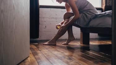 Frau sprüht Bein mit Tinktur ein
